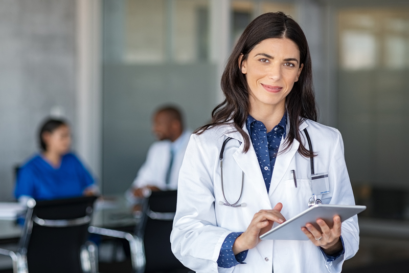 toronto-bioidentical-hormone-doctors-choosing-right-doctor Female bioidentical doctor holding tablet, with stethoscope around her neck